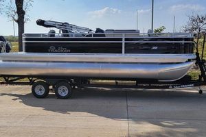 Sun Tracker Fishin' Barge 22 XP3 2026 Sun Tracker Fishin' Barge 22 XP3 pontoon boat on trailer, parked outdoors.