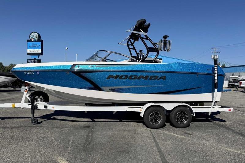 Moomba Max 2021 Moomba Max boat in blue on a trailer at a dealership.