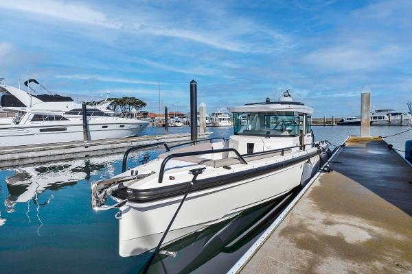 Axopar 28 CABIN 2022 Axopar 28 CABIN boat docked at a marina on a sunny day.