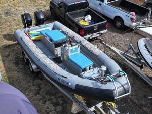 Zodiac Hurricane 733 2012 Zodiac 733 Hurricane inflatable boat on trailer, parked near pickup trucks.