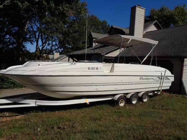 Bayliner 2659 Rendezvous 1998 Bayliner 2659 Rendezvous boat on a trailer in front of a house.