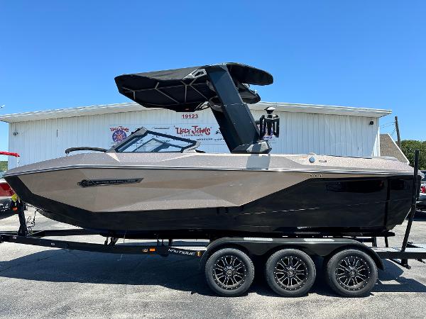 Nautique Super Air Nautique G23 2025 Nautique Super Air Nautique G23 boat on trailer, side view, sunny day.