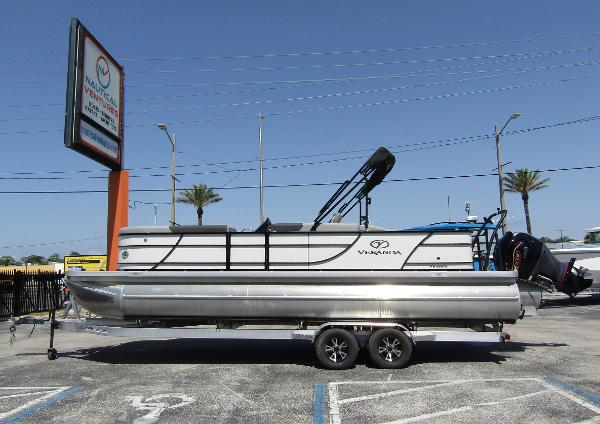 Veranda RELAX VR25RFL 2024 Veranda RELAX VR25RFL pontoon boat on trailer in parking lot, sunny day.