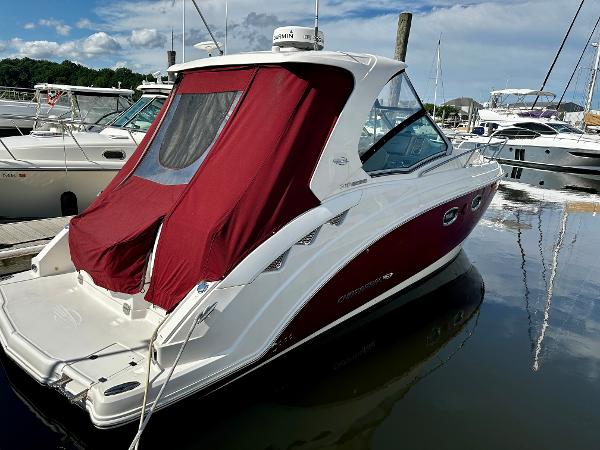 Chaparral 310 Signature 2013 Chaparral 310 Signature boat with red canopy docked at marina.