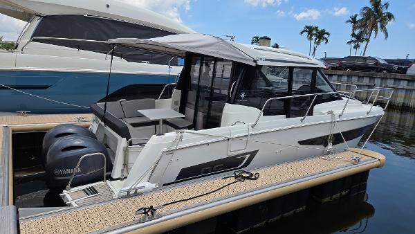 Jeanneau NC895 2019 Jeanneau NC895 boat docked, featuring twin Yamaha engines and a sleek design.