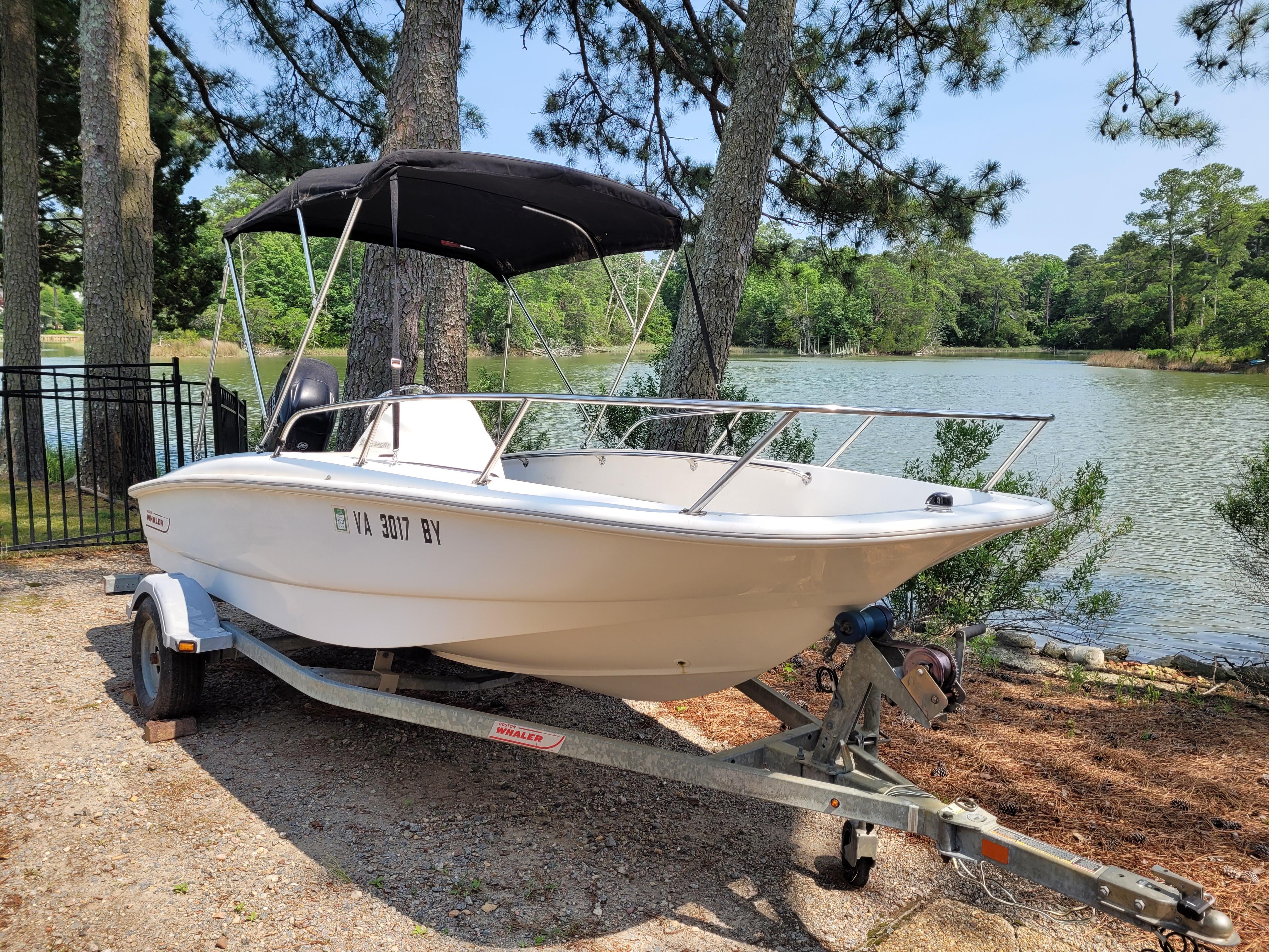 Boston Whaler 150 SS 2015 Boston Whaler 150 SS boat on trailer by a scenic lake.