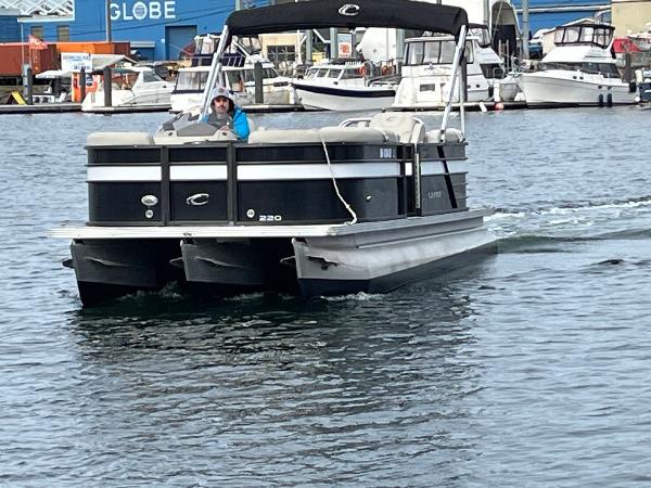 Crest Classic 220 DLX 2021 Crest Classic 220 DLX pontoon boat cruising in a marina with other boats.