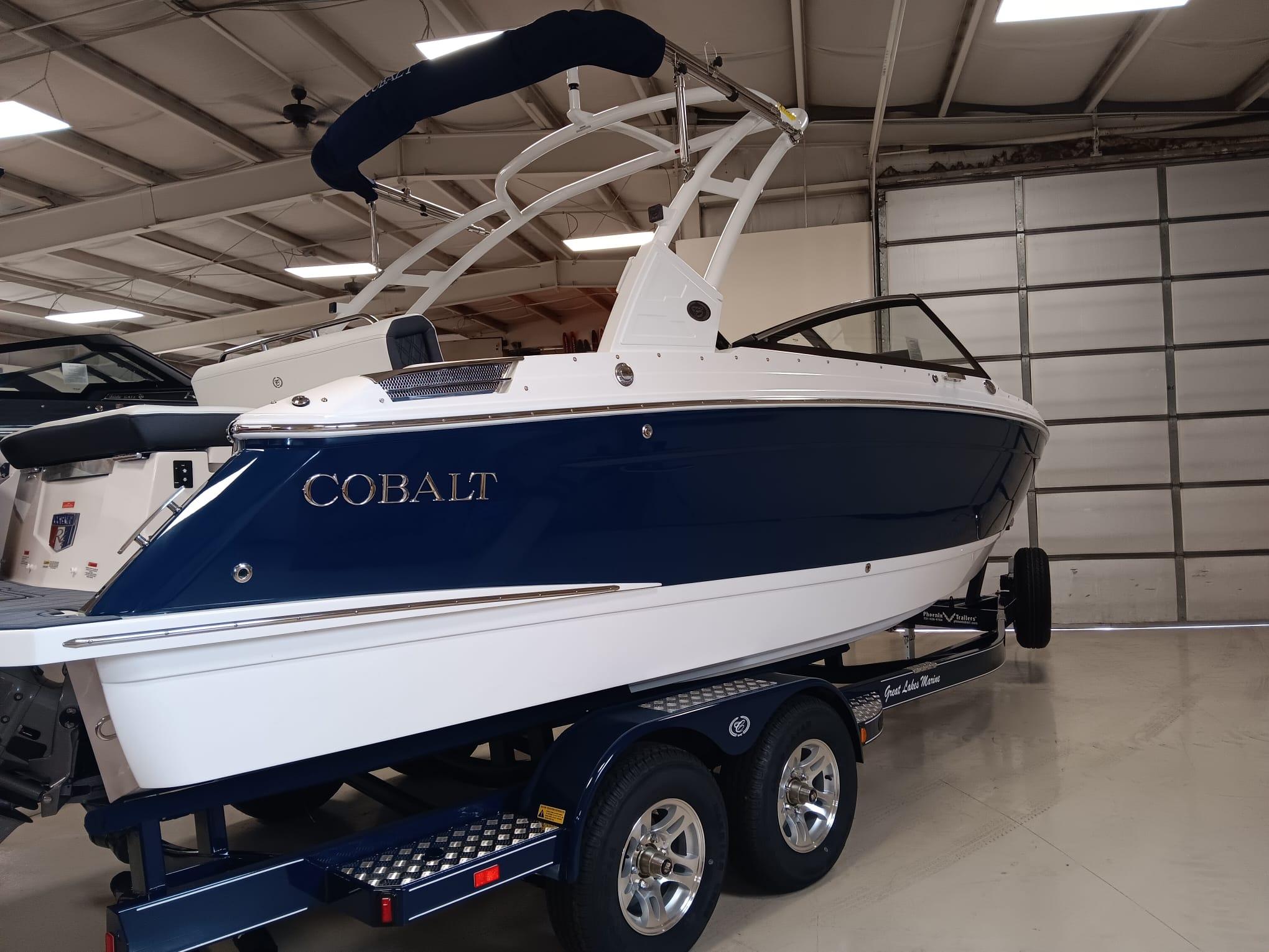 Cobalt R4 2026 Cobalt R4 boat in showroom, blue and white design, on trailer.