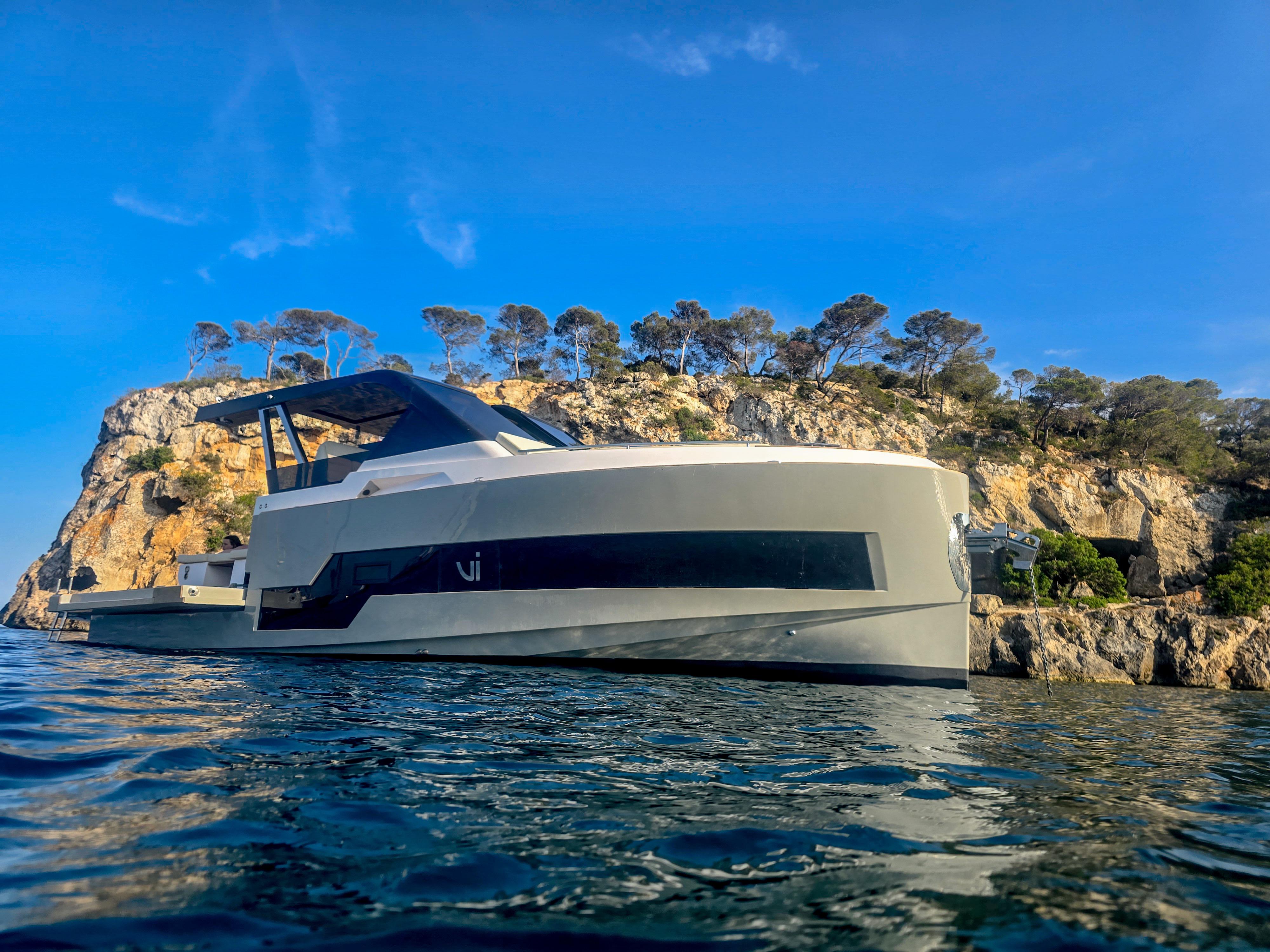 Custom Vi Yachts Q4 Luxurious 2025 Vi Yachts Q4 cruising near rocky coastline under clear blue sky.
