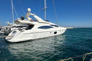 Azimut 68E 2009 Azimut 68E yacht docked in a marina under clear blue skies.