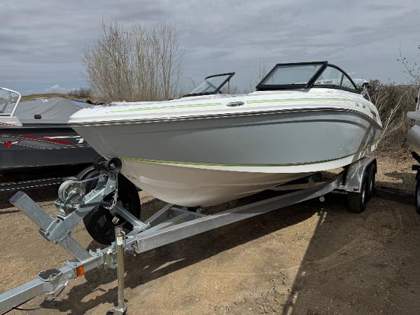 Tahoe 210 S 2024 Tahoe 210 S boat on trailer, parked outdoors, under cloudy sky.