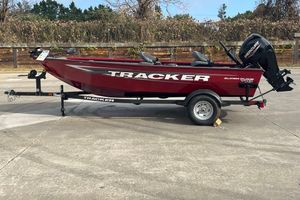 Tracker Super Guide V-16 T 2026 Tracker Super Guide V-16 T boat on trailer, red exterior, parked outdoors.