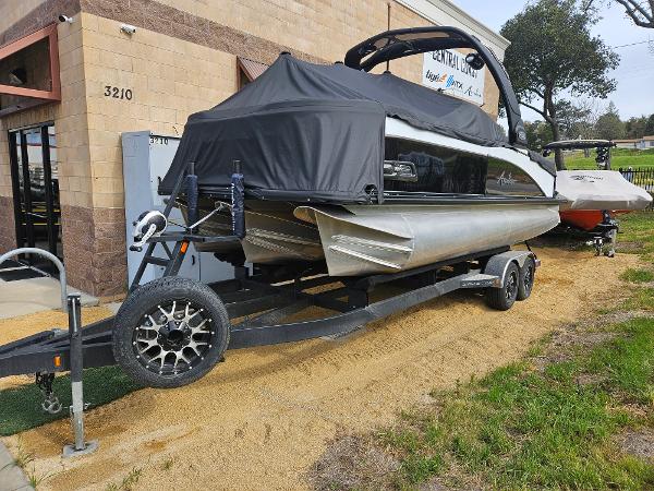 Avalon Waketoon 2024 Avalon Waketoon boat on trailer, covered, parked outside a building.