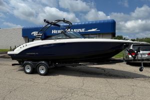 Chaparral 23 SSi 2025 Chaparral 23 SSi boat on trailer outside marine dealership.