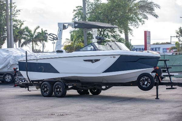 Nautique S25 2023 Nautique S25 boat on a trailer in a parking lot.