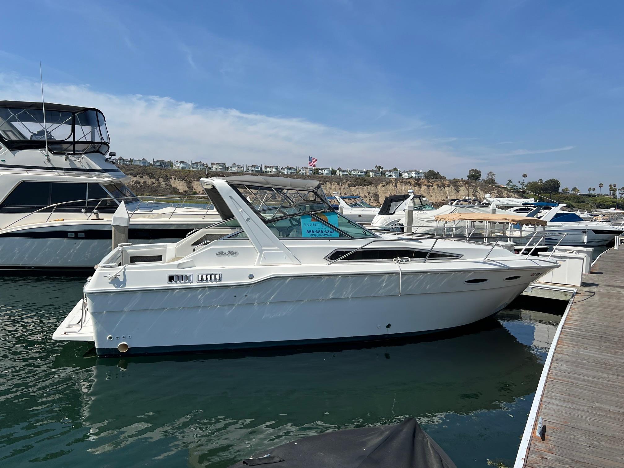 Sea Ray 300 Sundancer 1989 Sea Ray 300 Sundancer docked at marina under clear blue sky.