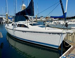 Hunter 29.5 1994 Hunter 29.5 sailboat docked in marina, featuring sleek white hull and blue accents.