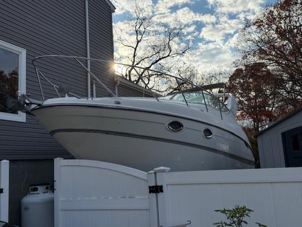 Maxum 2700 SCR 2002 Maxum 2700 SCR boat docked beside a house under a partly cloudy sky.