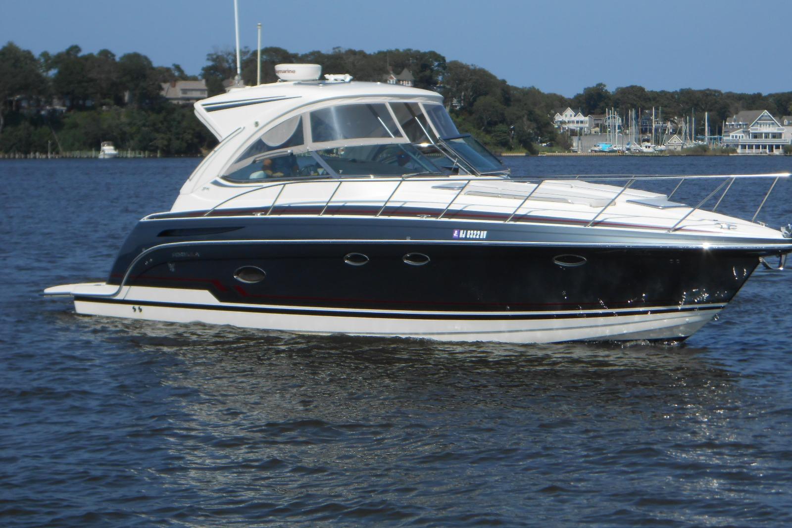 Formula 37 PC 2017 Formula 37 PC yacht cruising on a calm lake with scenic background.