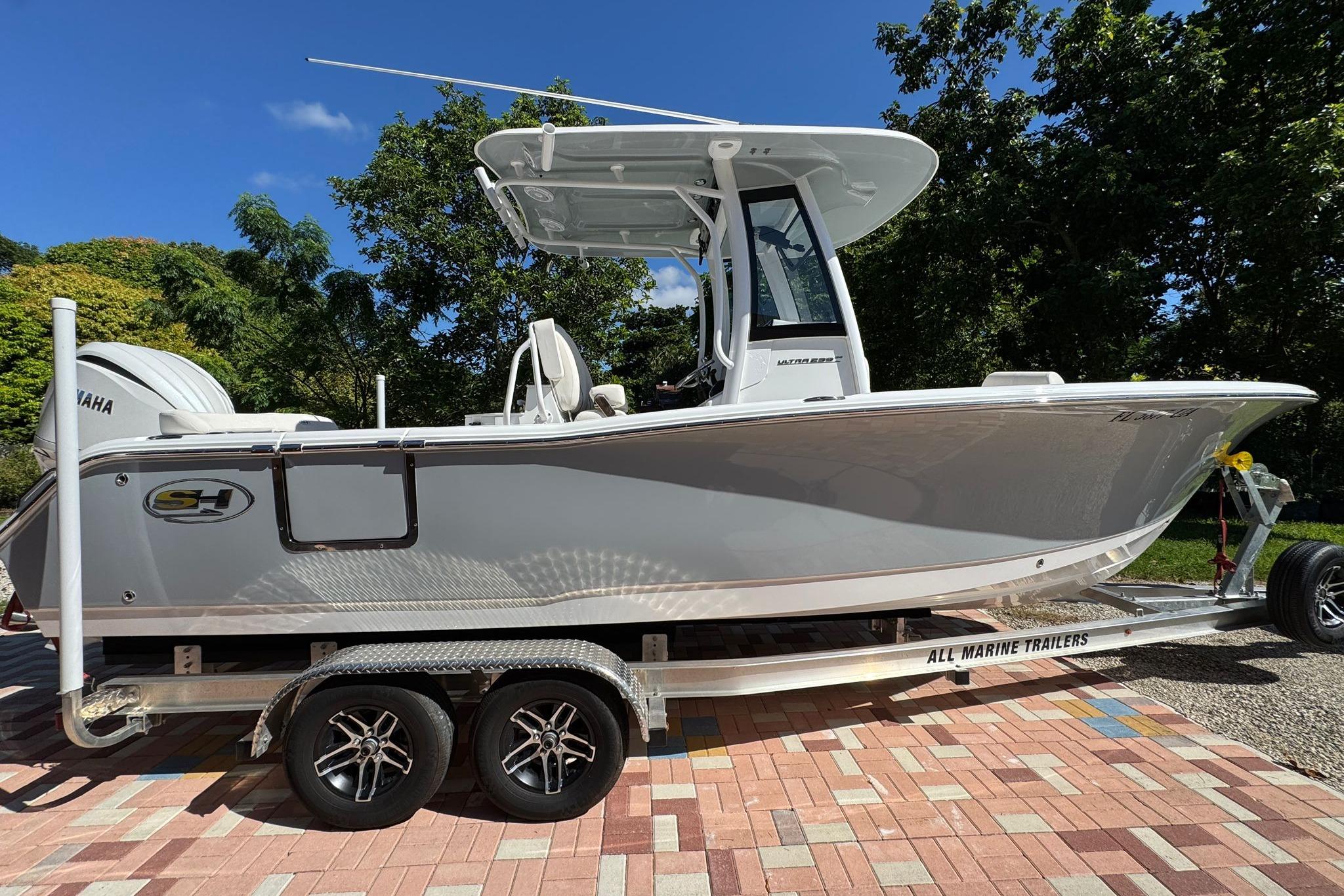 Sea Hunt Ultra 239 SE 2025 Sea Hunt Ultra 239 SE boat on trailer, parked outdoors, with Yamaha engine.