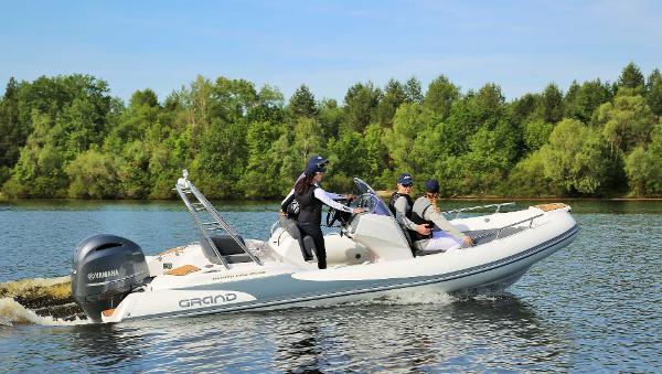 Grand Inflatables G580 2024 Grand Inflatables G580 boat cruising on a lake with passengers.