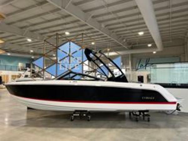 Cobalt CS23 2024 Cobalt CS23 boat in showroom, black hull with red stripe, modern design.