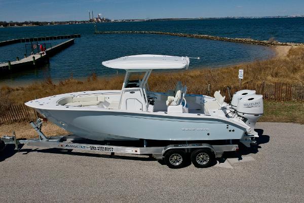 Cape Horn 24 XS 2025 Cape Horn 24 XS boat on trailer by waterfront, featuring sleek design and dual engines.