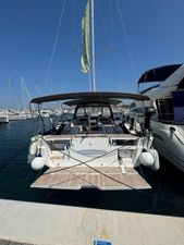 Dufour 530 2021 Dufour 530 yacht docked at marina, featuring spacious deck and dual steering wheels.
