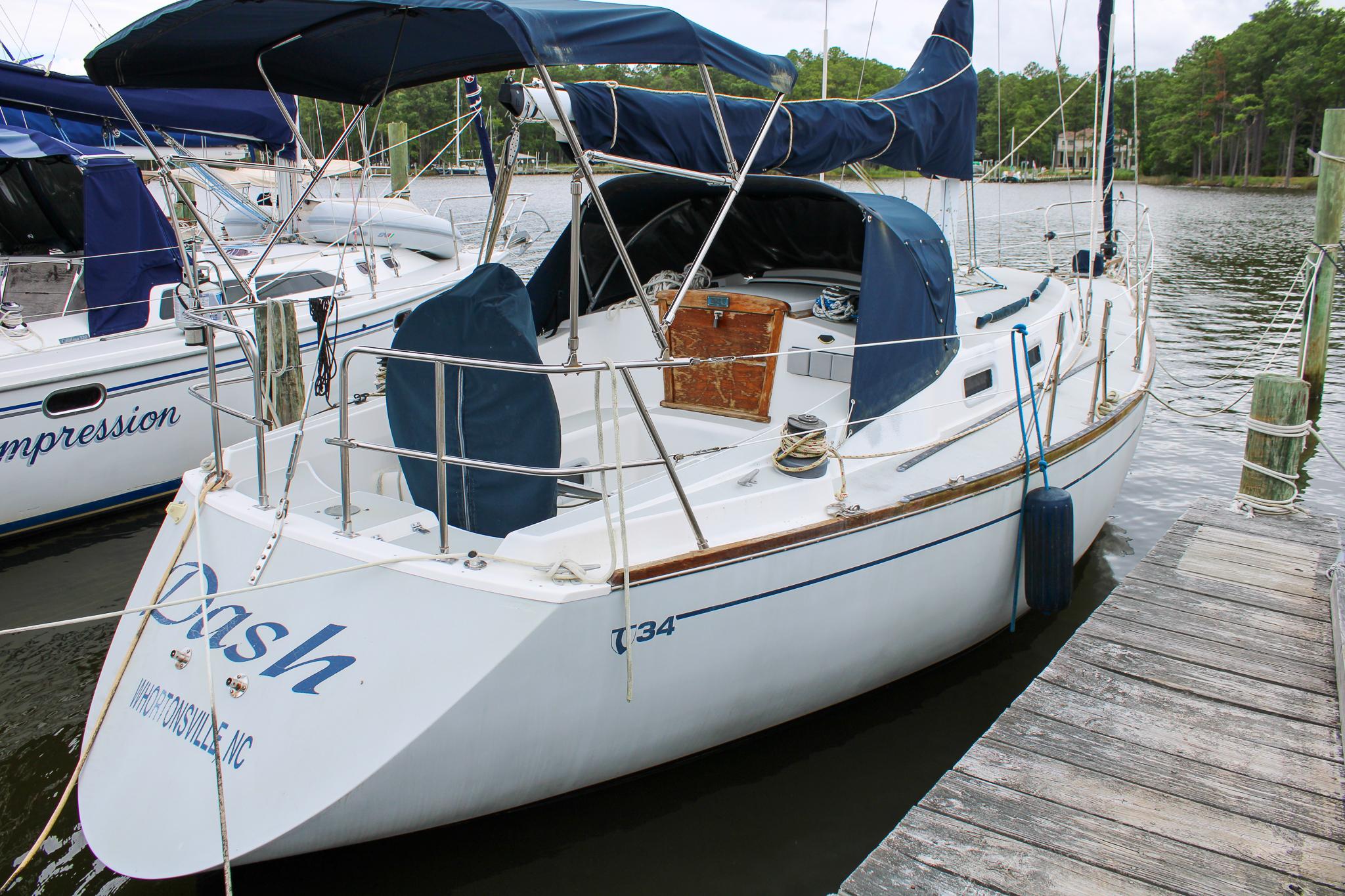 Tartan 34 1987 Tartan 34 sailboat docked, featuring blue canvas covers and wooden accents.