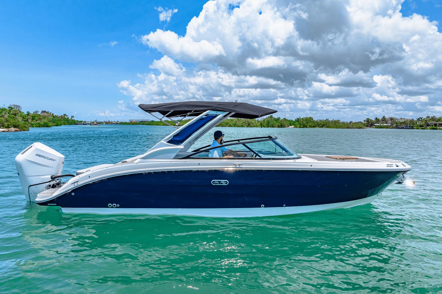 Sea Ray SDX 270 Outboard 2025 Sea Ray SDX 270 Outboard boat on clear water under a blue sky.