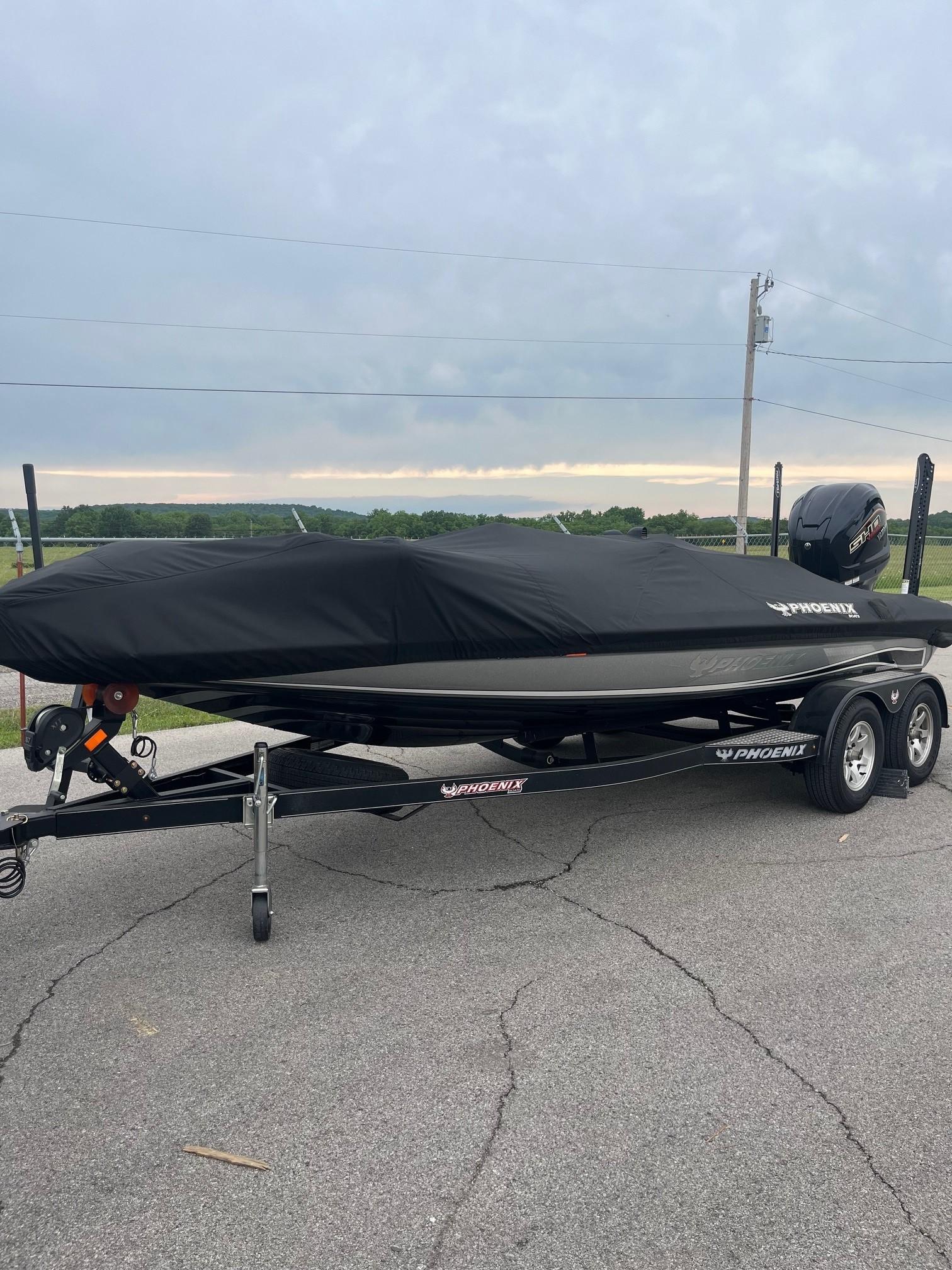 Phoenix 819 Pro 2024 Phoenix 819 Pro boat covered on trailer, parked on asphalt.