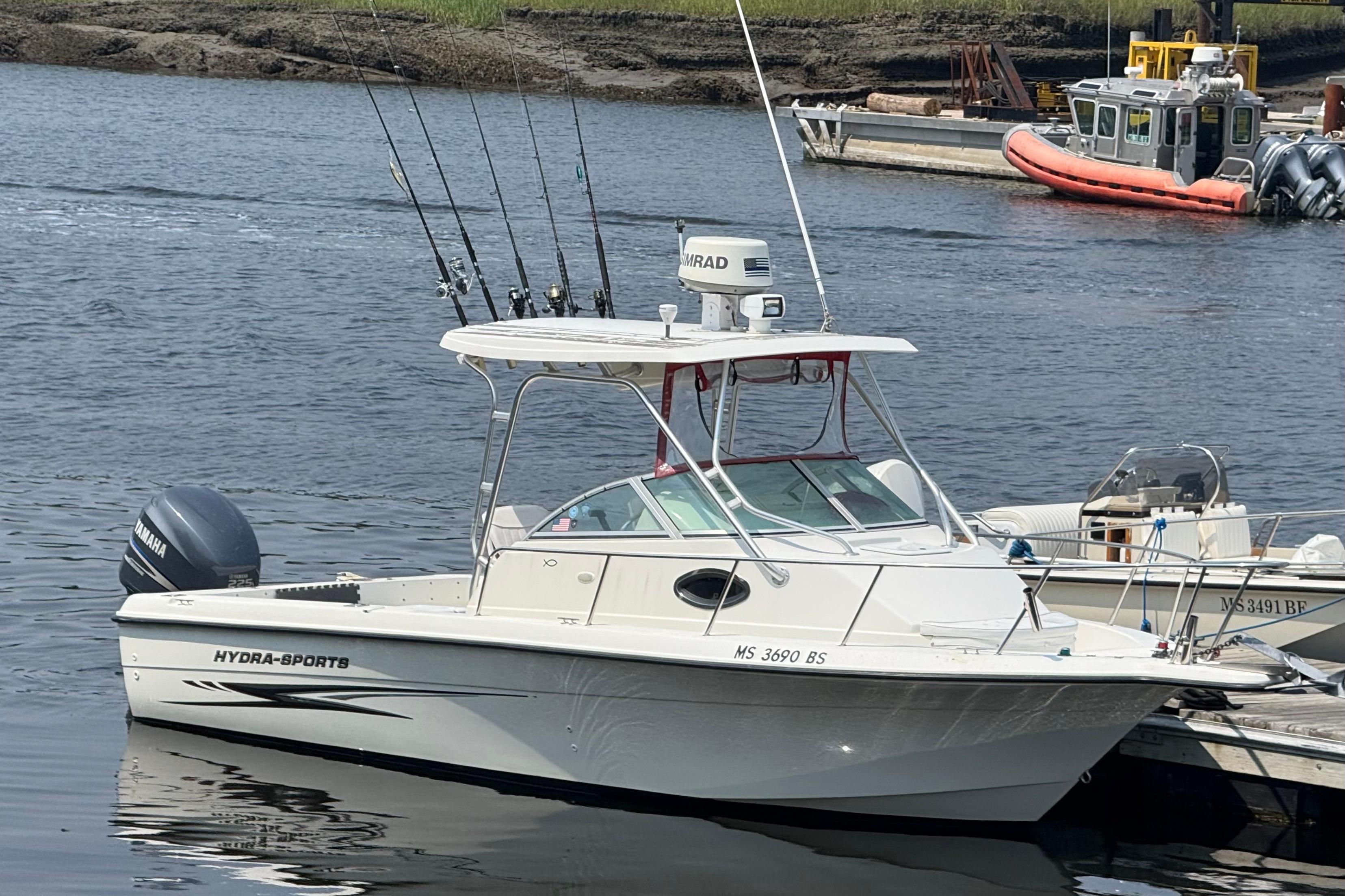Hydra-Sports Lightning 230 WA 2004 Hydra-Sports Lightning 230 WA boat docked, equipped with fishing rods and Yamaha engine.