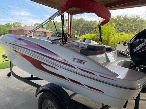 Tahoe T16 2024 Tahoe T16 boat with red accents on a trailer under a canopy.