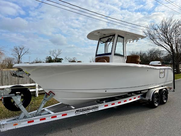 Sea Hunt Ultra 255 SE 2025 Sea Hunt Ultra 255 SE boat on trailer, parked on a road under a cloudy sky.