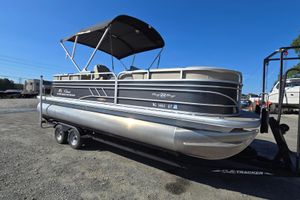 Sun Tracker Party Barge 22 RF DLX 2023 Sun Tracker Party Barge 22 RF DLX pontoon boat on trailer, parked outdoors.