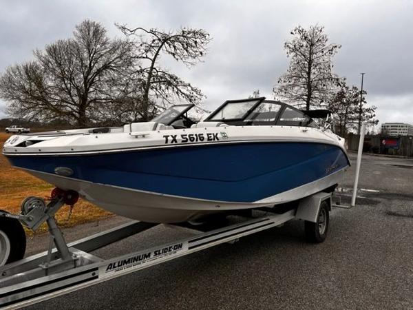 Scarab 215 2014 Scarab 215 boat on aluminum trailer in parking lot.