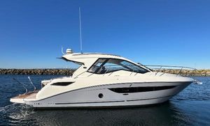 Sea Ray Sundancer 350 Coupe 2018 Sea Ray Sundancer 350 Coupe cruising on calm waters under clear blue sky.