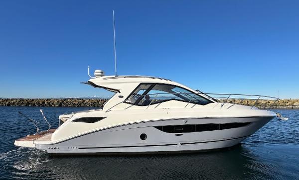 Sea Ray Sundancer 350 Coupe 2018 Sea Ray Sundancer 350 Coupe cruising on calm waters under clear blue sky.