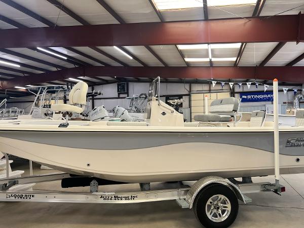 Carolina Skiff 21 LS 2024 Carolina Skiff 21 LS boat on trailer in indoor showroom.