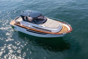 Mimi 11 Modern Mimi 11 boat on sparkling water, 2023 model, featuring sleek design and wooden accents.