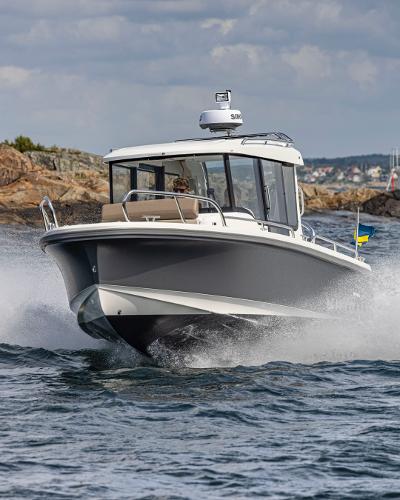 Nimbus C8 2025 Nimbus C8 boat cruising on open water near rocky coastline.