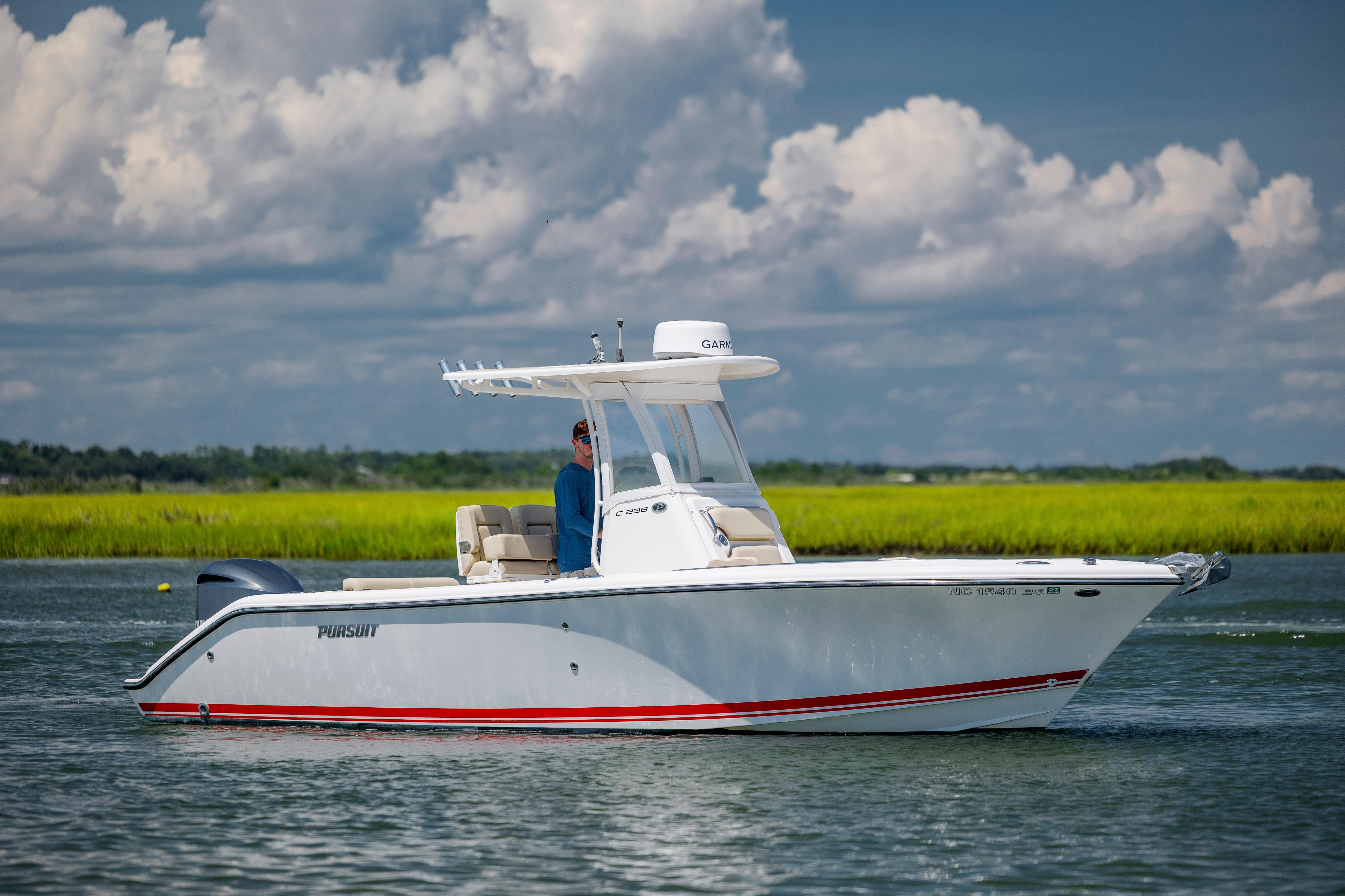 Pursuit C 238 Center Console 2018 Pursuit C 238 Center Console boat on calm water under a cloudy sky.