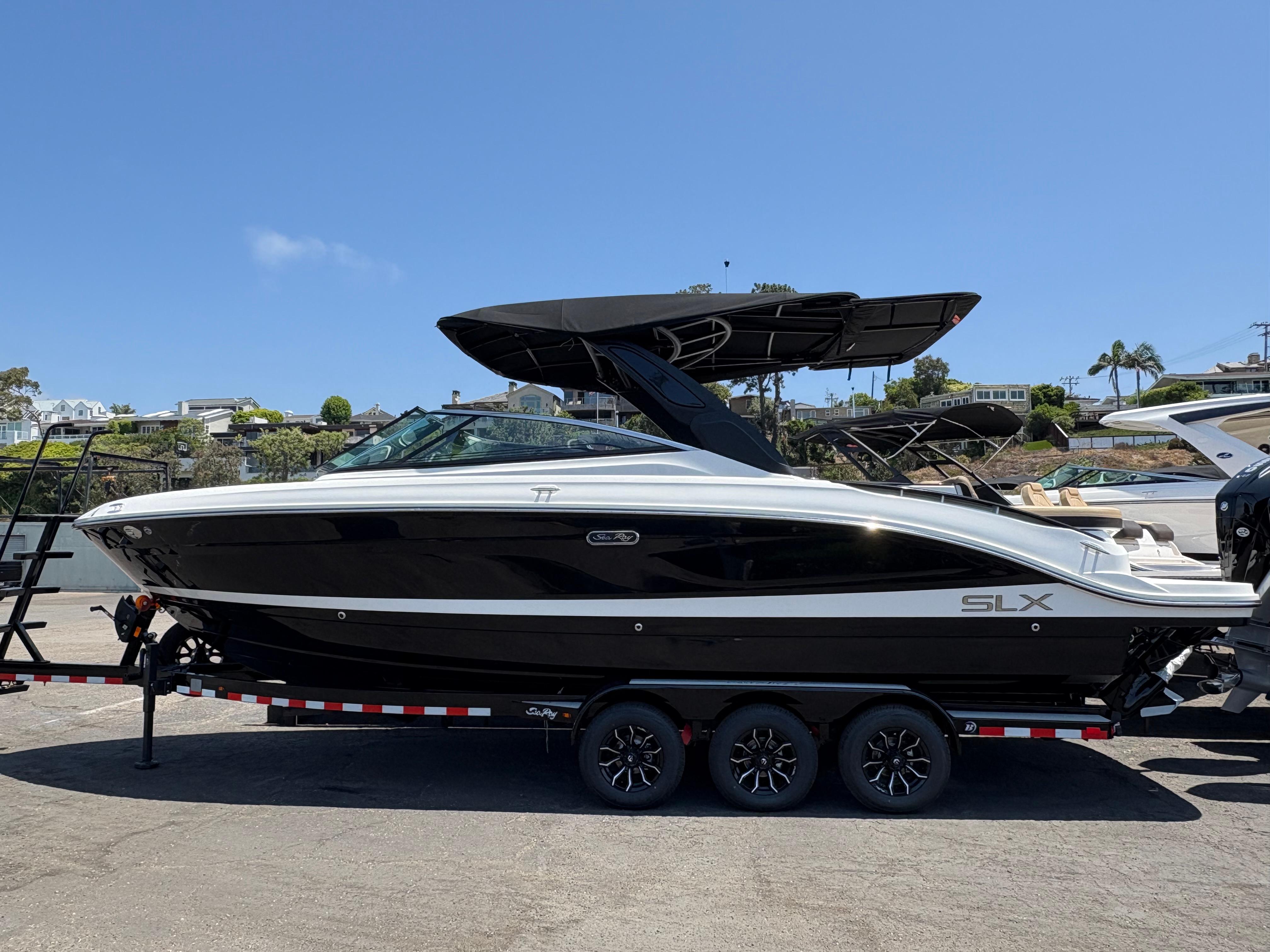 Sea Ray SLX 280 2026 Sea Ray SLX 280 boat on trailer, sleek black and white design, sunny day.