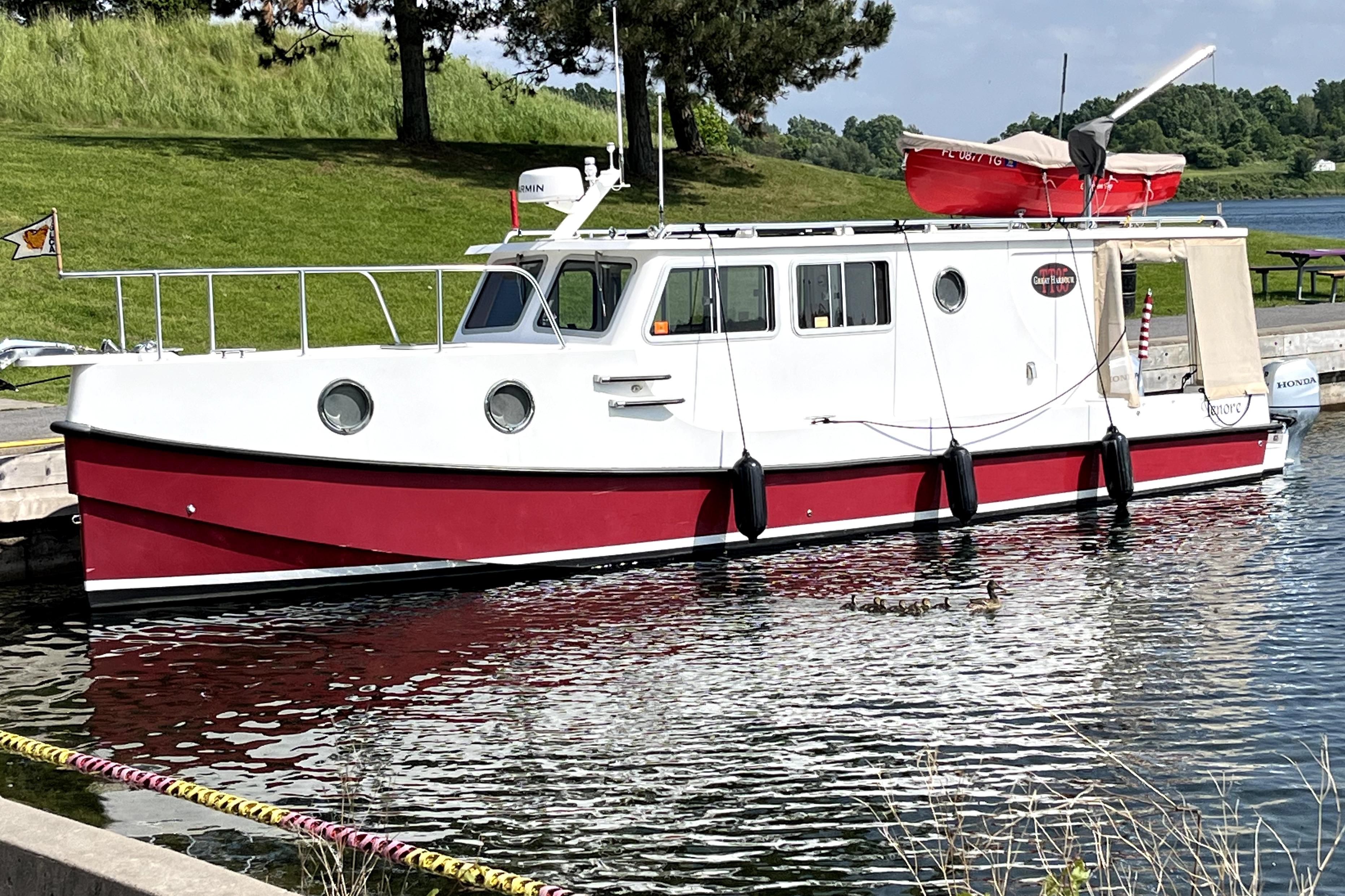 Great Harbour TT35 2023 Great Harbour Trawlers TT35 boat docked on a calm lake with lush greenery.
