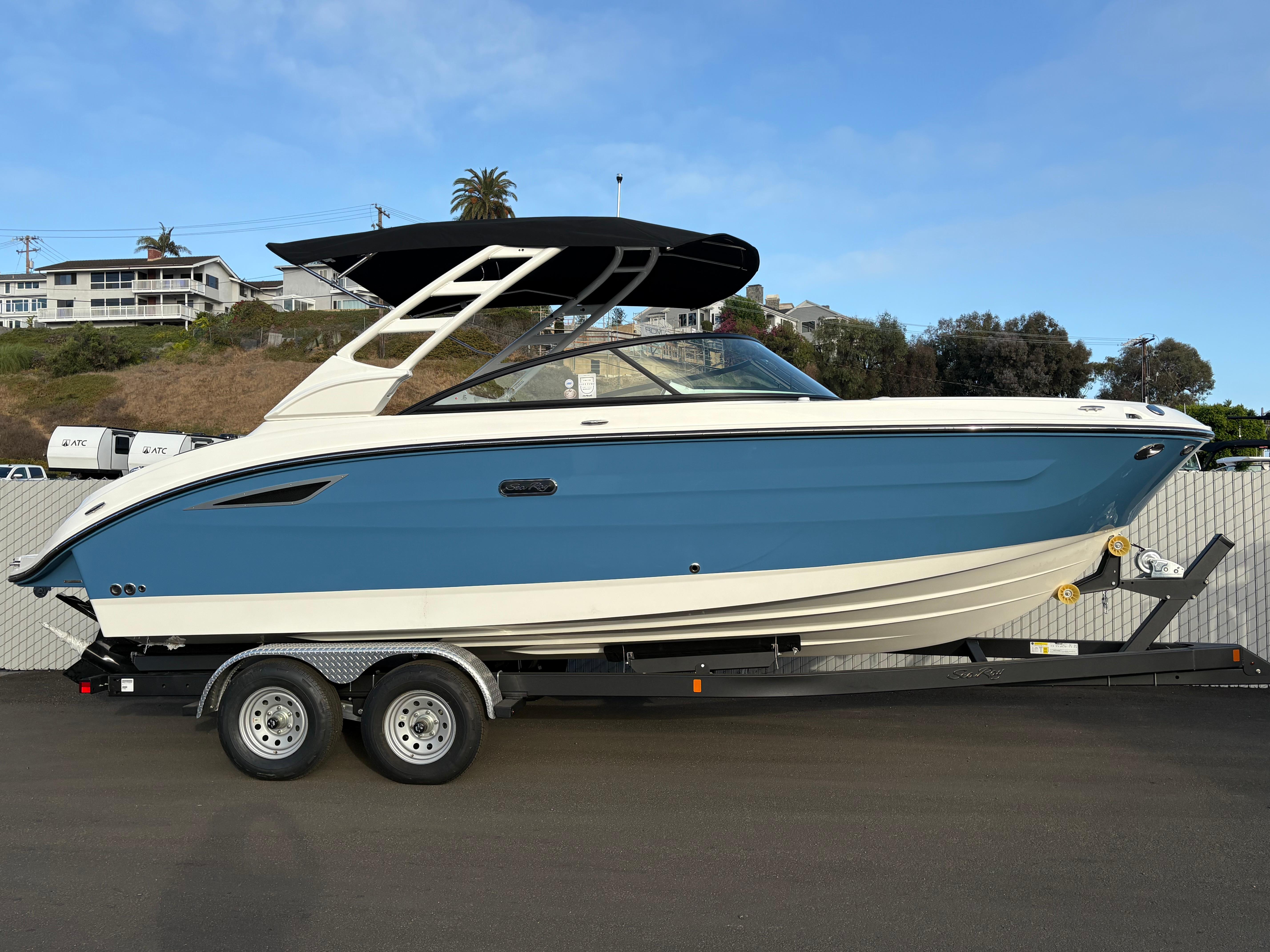 Sea Ray SDX 250 2026 Sea Ray SDX 250 boat on trailer, blue and white design, parked outdoors.