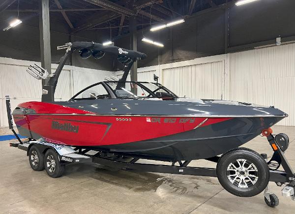 Malibu 23 LSV 2017 Malibu 23 LSV boat in red and black on a trailer in a warehouse.