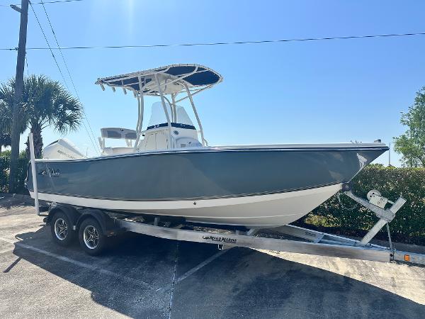 Mako 214 CC 2024 Mako 214 CC boat on trailer, parked outdoors under clear blue sky.