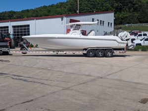 Sunsation 32CCX 2018 Sunsation 32CCX boat on trailer in parking lot, near industrial building.