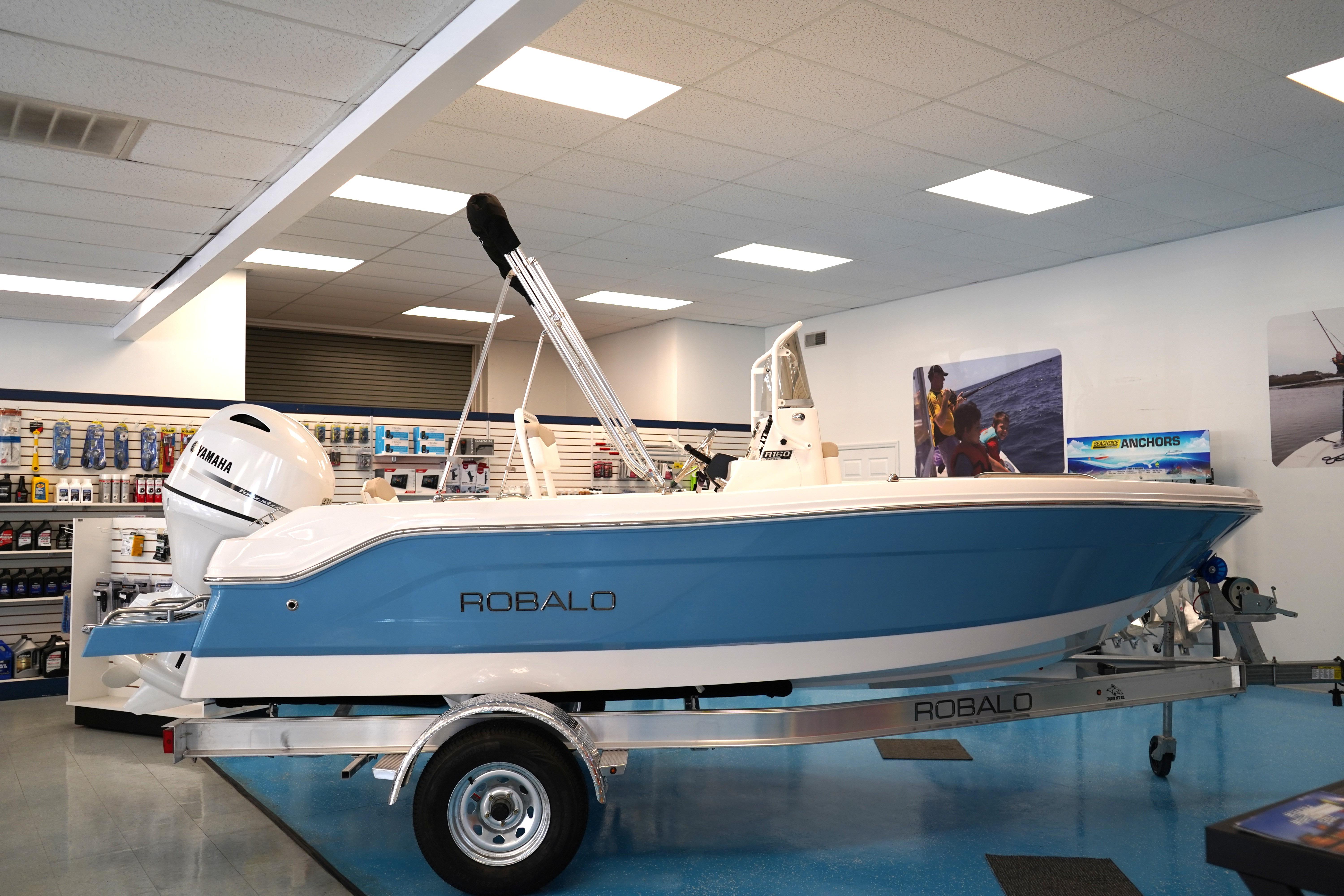 Robalo R160 Center Console 2026 Robalo R160 Center Console boat displayed in showroom with Yamaha engine.