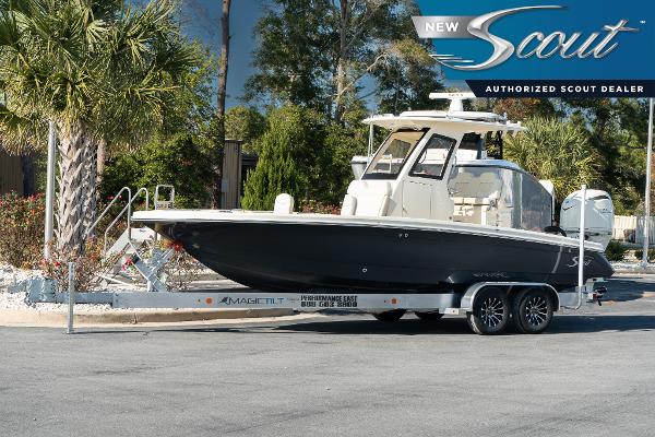 Scout 261 XSS 2025 Scout 261 XSS boat on trailer at authorized dealer, surrounded by trees.